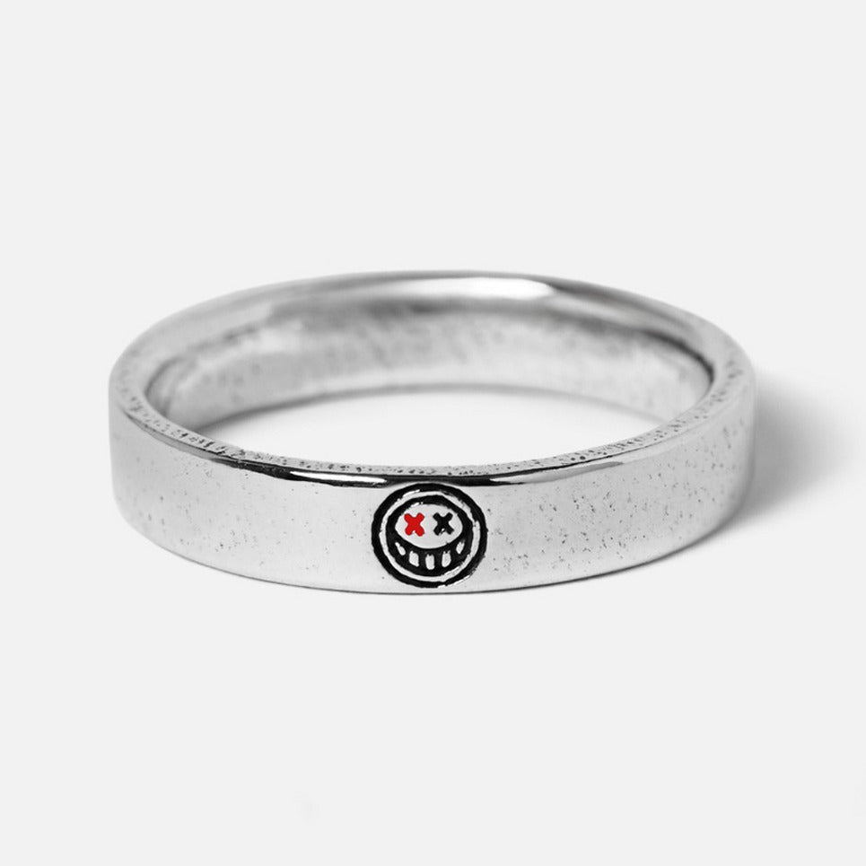 A sterling silver Reflection Ring from Billie Jo, featuring a unique engraved smiley face with red 'X' eyes. This men's ring has a modern, minimalist style.