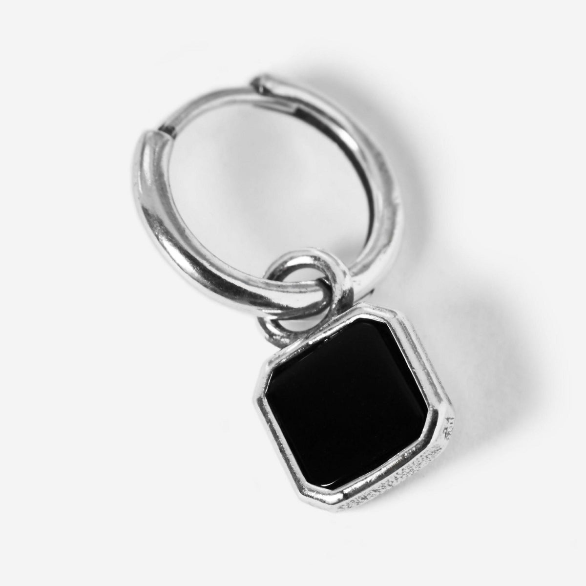 A single sterling silver Nox Earring from Billie Jo, showcasing the huggie hoop and the faceted black stone pendant in a detailed product shot.