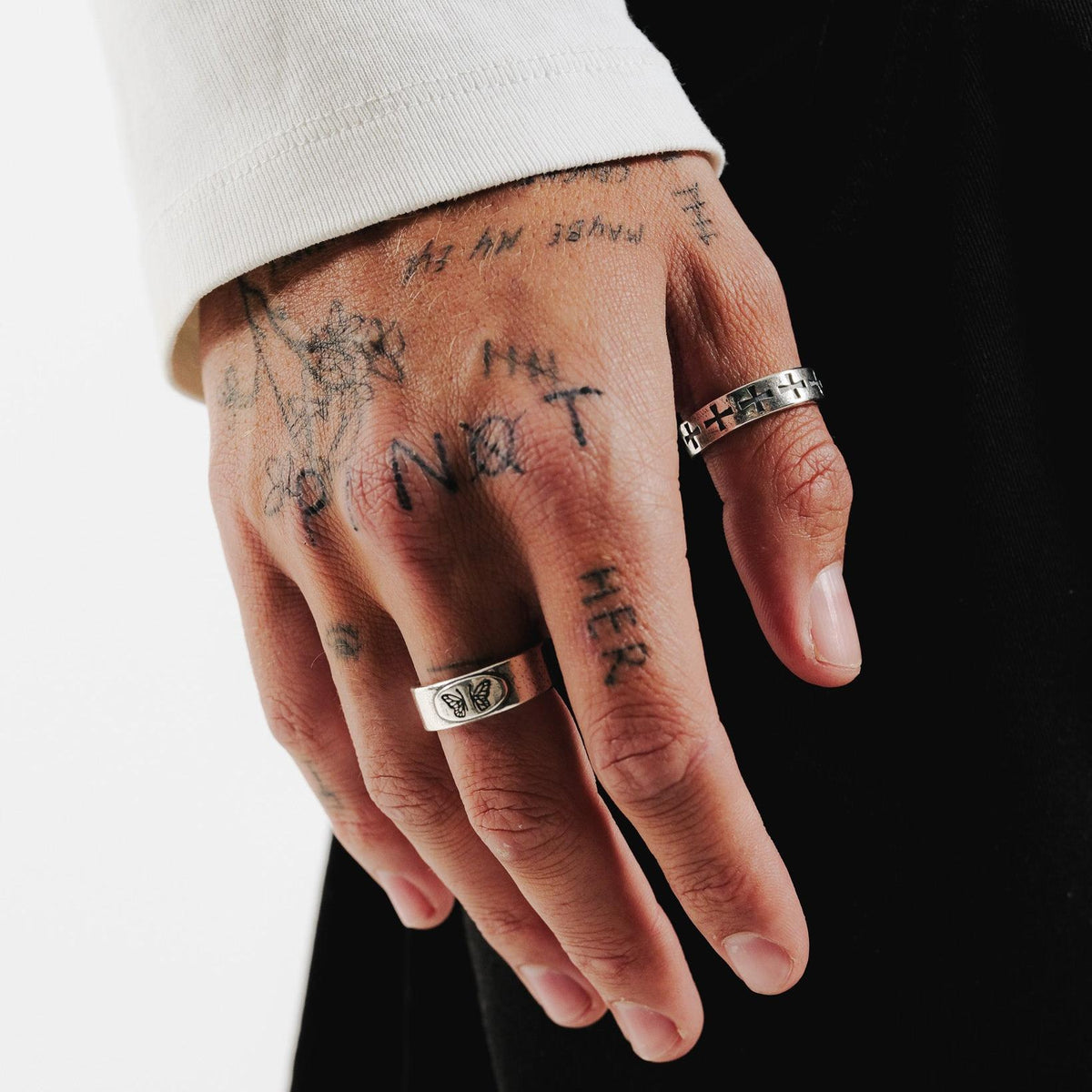 On-hand shot of the sterling silver Sanctum Ring by Billie Jo, showing the carved cross design. Styled on a tattooed hand for a modern, edgy aesthetic.