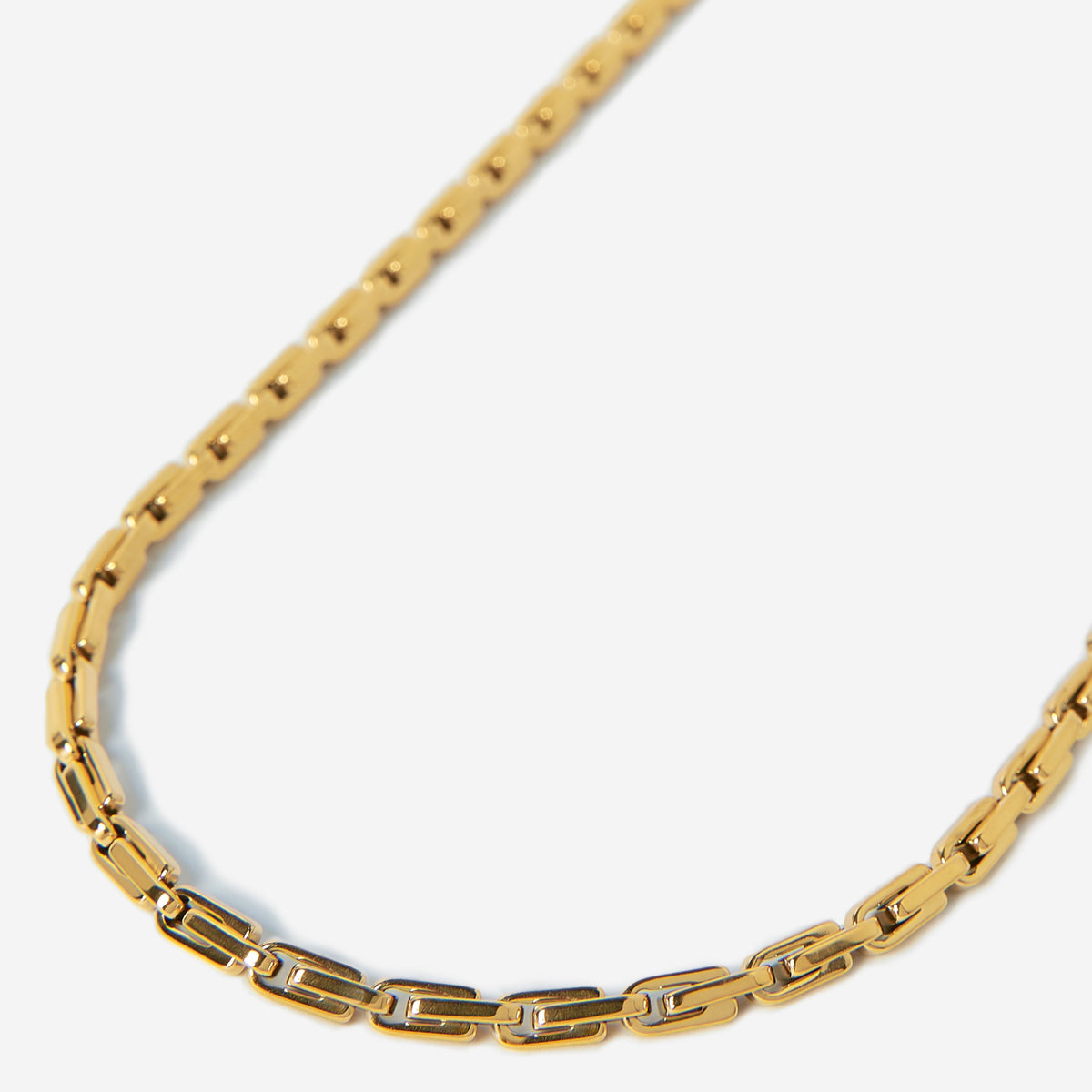 Gold chain necklace on a light gray background