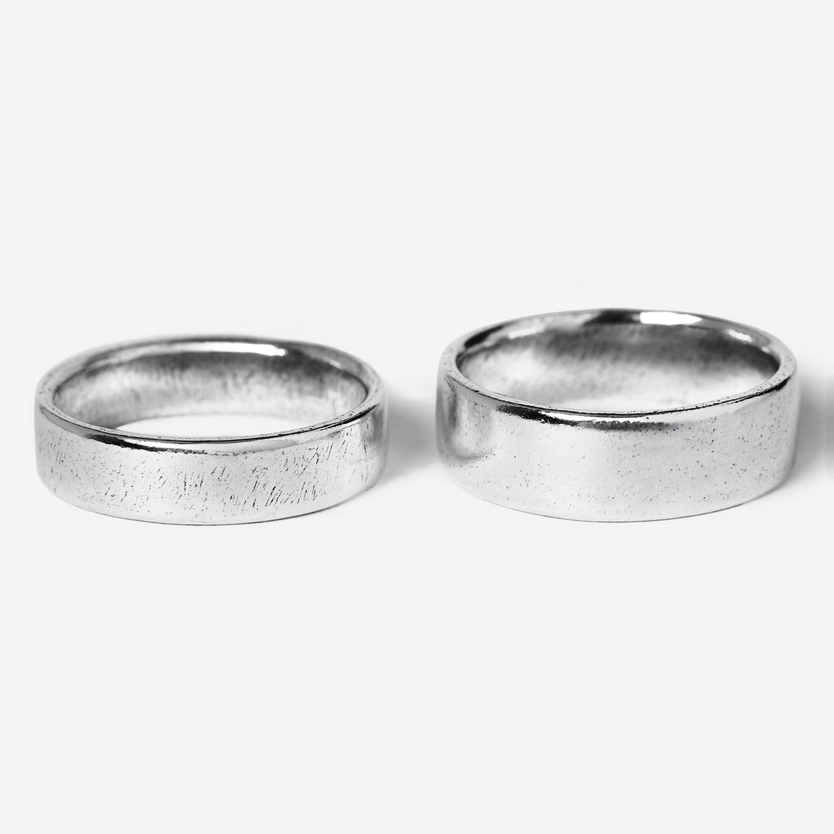 A pair of men's sterling silver rings from the Billie Jo Canvas & Serenity set, shown on a clean white background. The Canvas ring features a unique textured finish, while the Serenity ring has a classic polished look, offering versatile Australian jewellery styling.