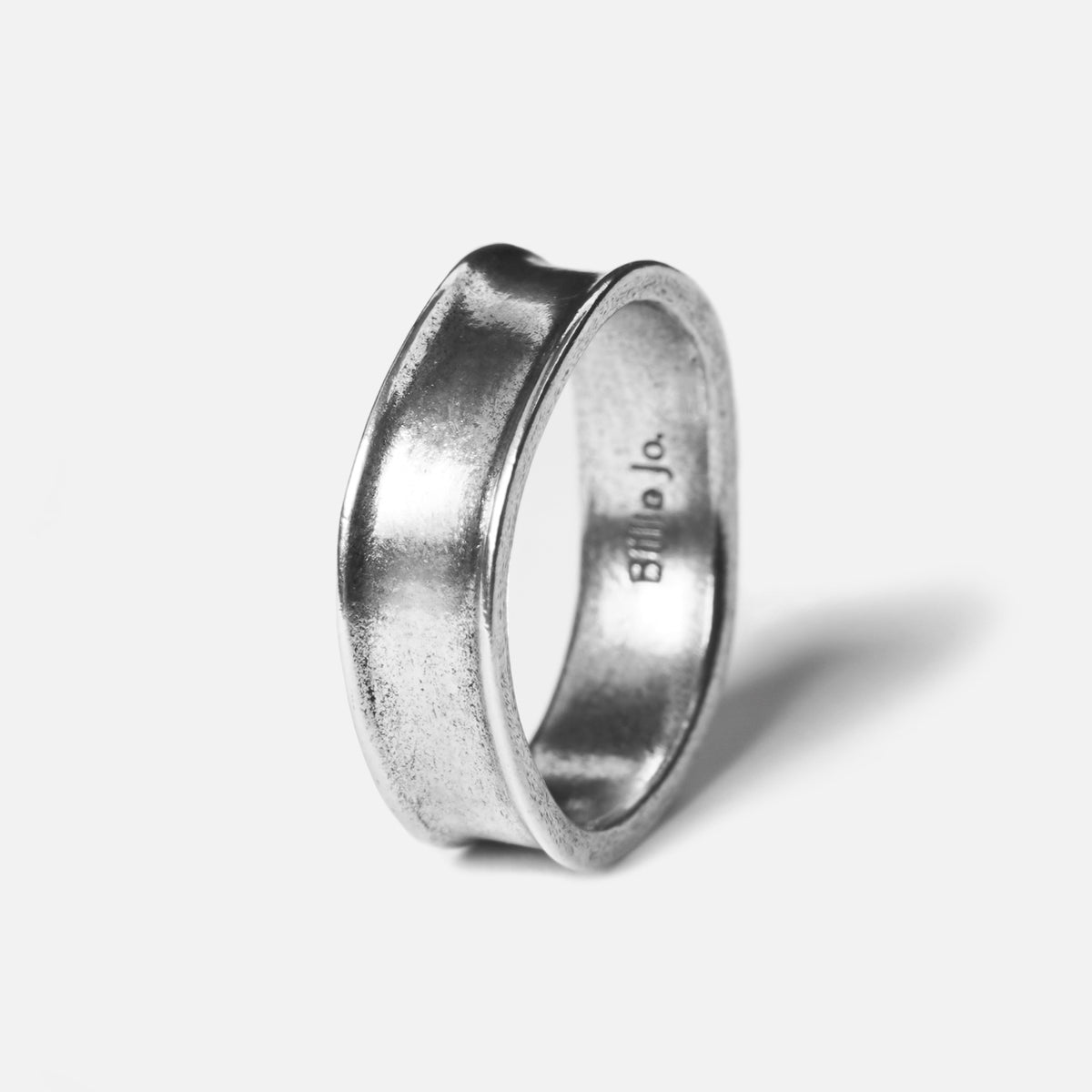 A sterling silver Forge Ring by Billie Jo, with a unique forged and hammered texture creating a modern, concave shape. Shot on a clean white background.