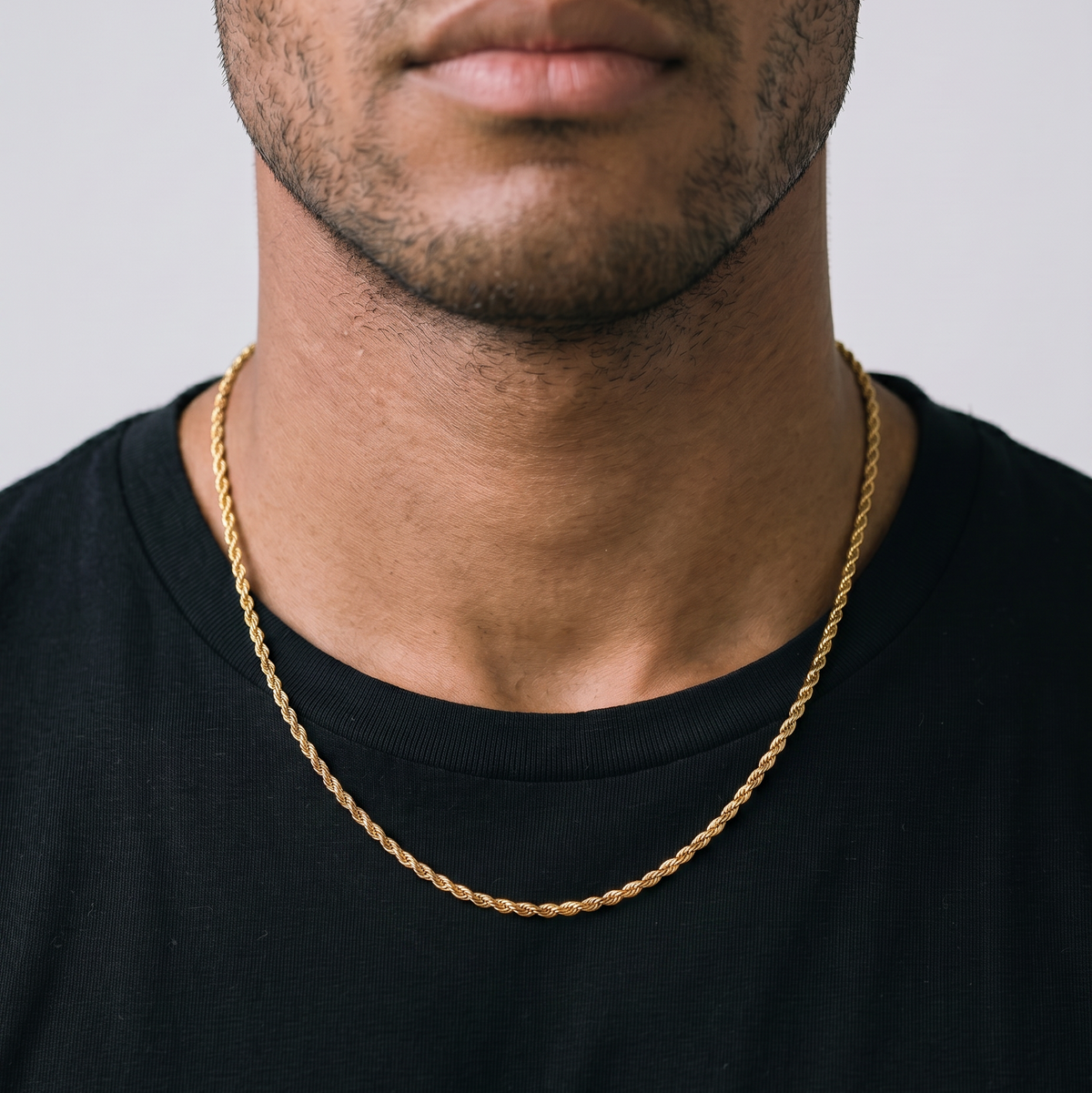 A gold tone stainless steel slim rope chain set from Australian jewellery brand Billie Jo, worn by a male model against a warm gold backdrop, a waterproof sweat proof everyday necklace and the perfect gift for him.