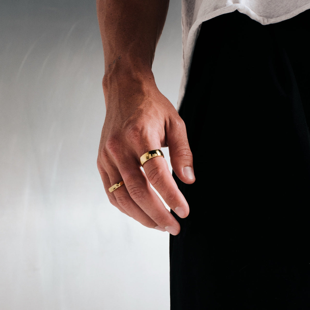 Men's Gold Canvas Ring in 18k gold infused stainless steel, worn on his right index finger, hand hanging by his side