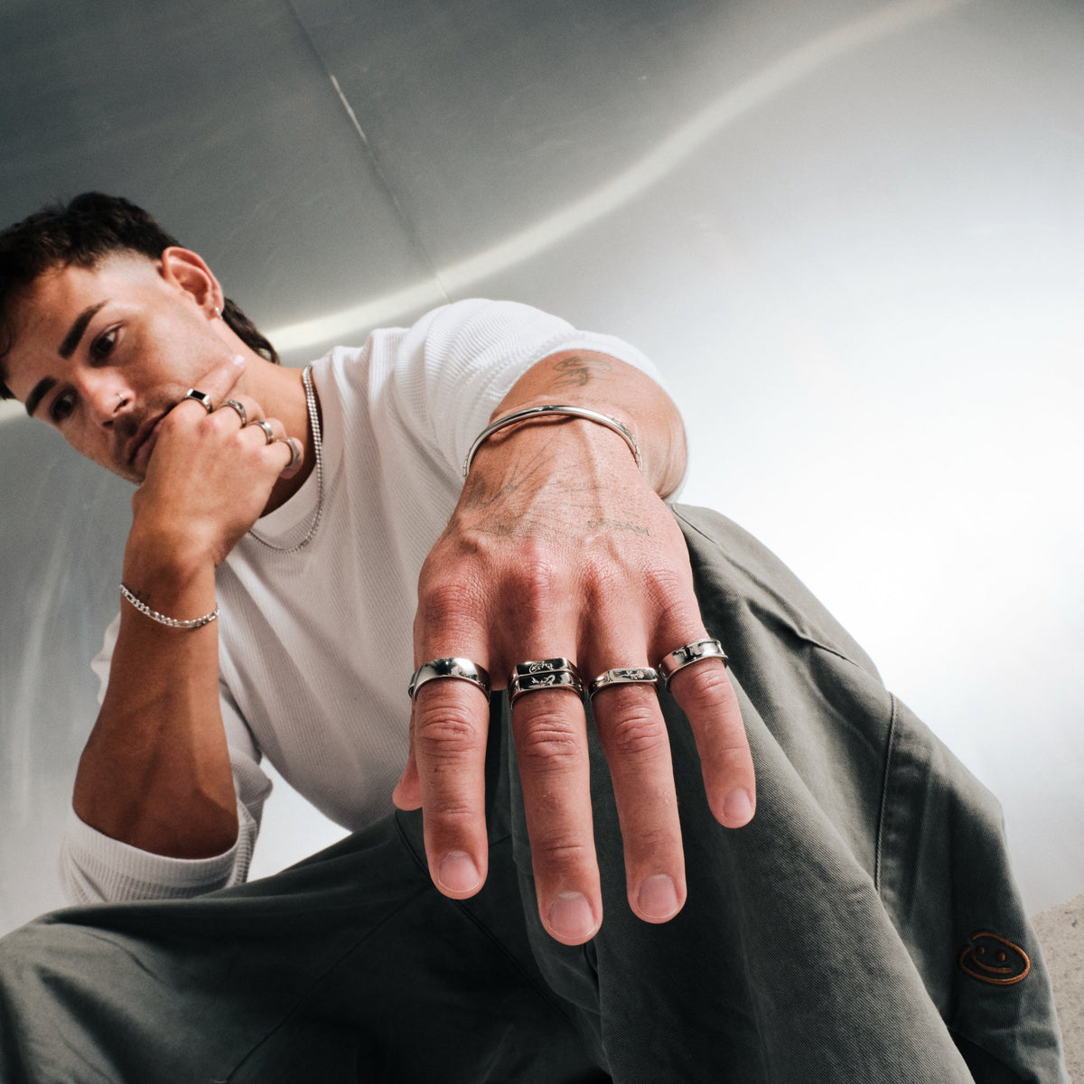 Men's Koi Stackers in 316L stainless steel, silver finish, both worn on one finger, white waffle top, olive pants