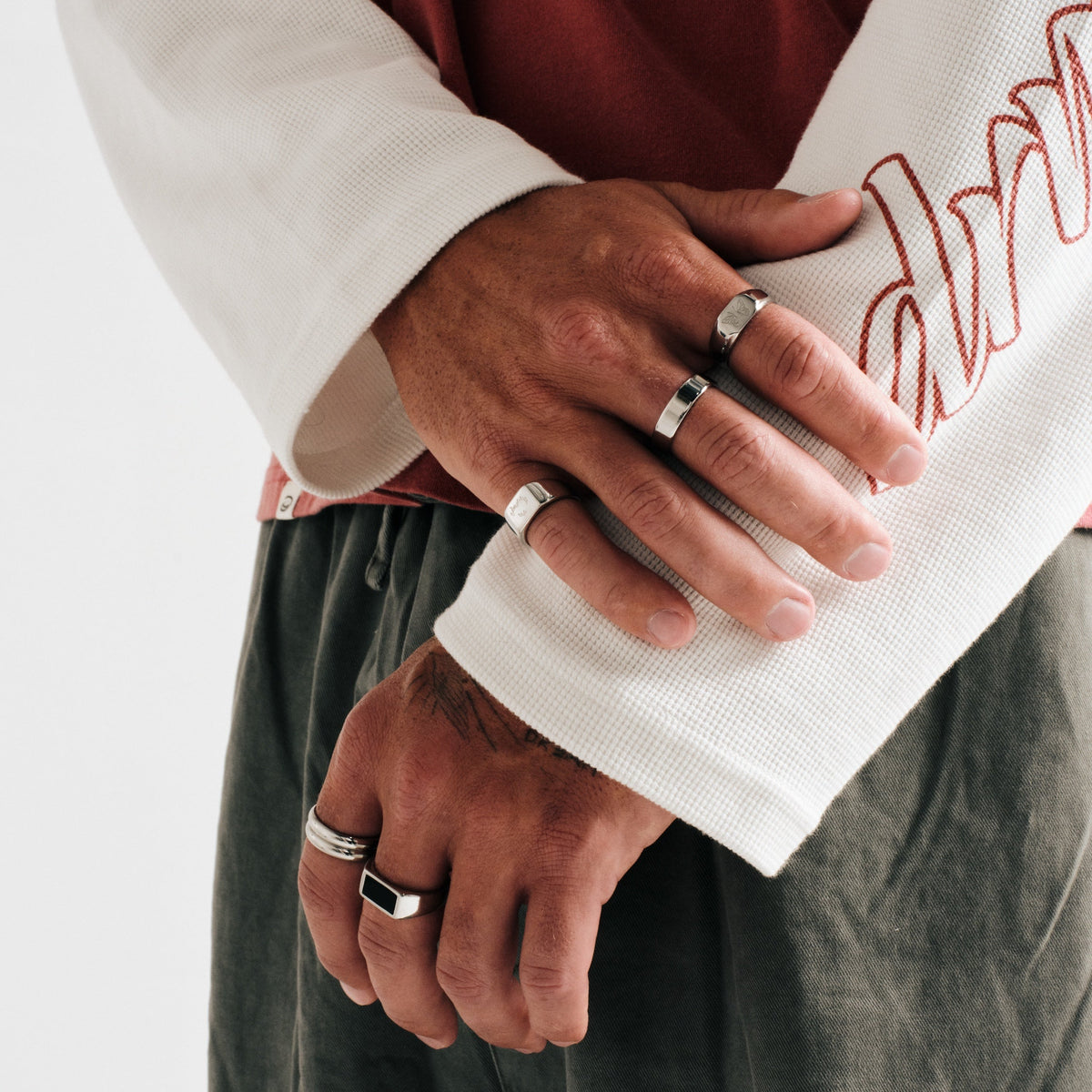 Men's Serenity Ring in 316L stainless steel, silver finish, worn on the middle finger, arms crossed