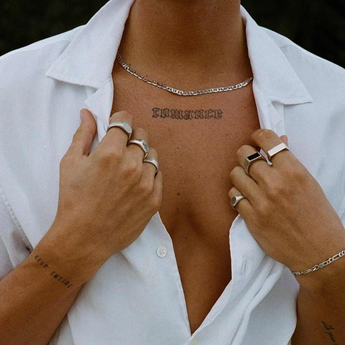 Close-up of a man\'s chest showing the Billie Jo Mariner Necklace resting on his skin, paired with an unbuttoned white shirt and silver rings.