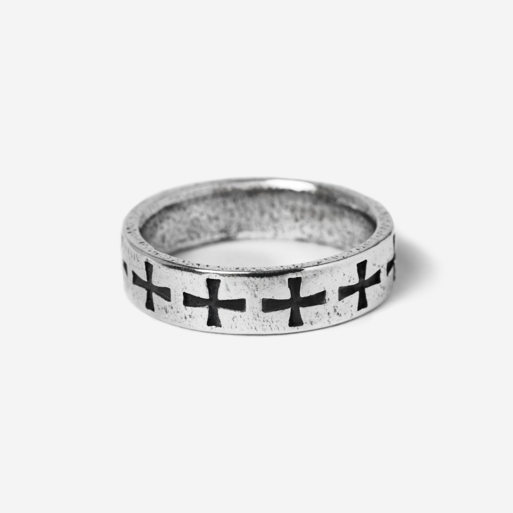 Silver ring with black cross designs on a white background