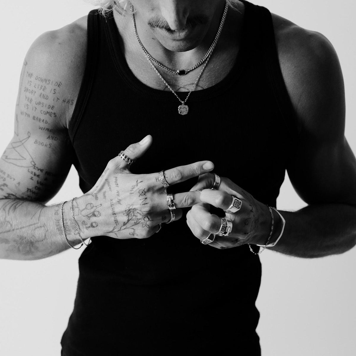 A model wears the Billie Jo Slim Batch Bracelet as part of a layered silver jewellery look, with multiple rings, necklaces, and another bracelet.
