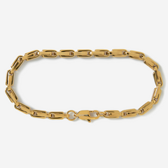 Gold chain bracelet on a light gray background