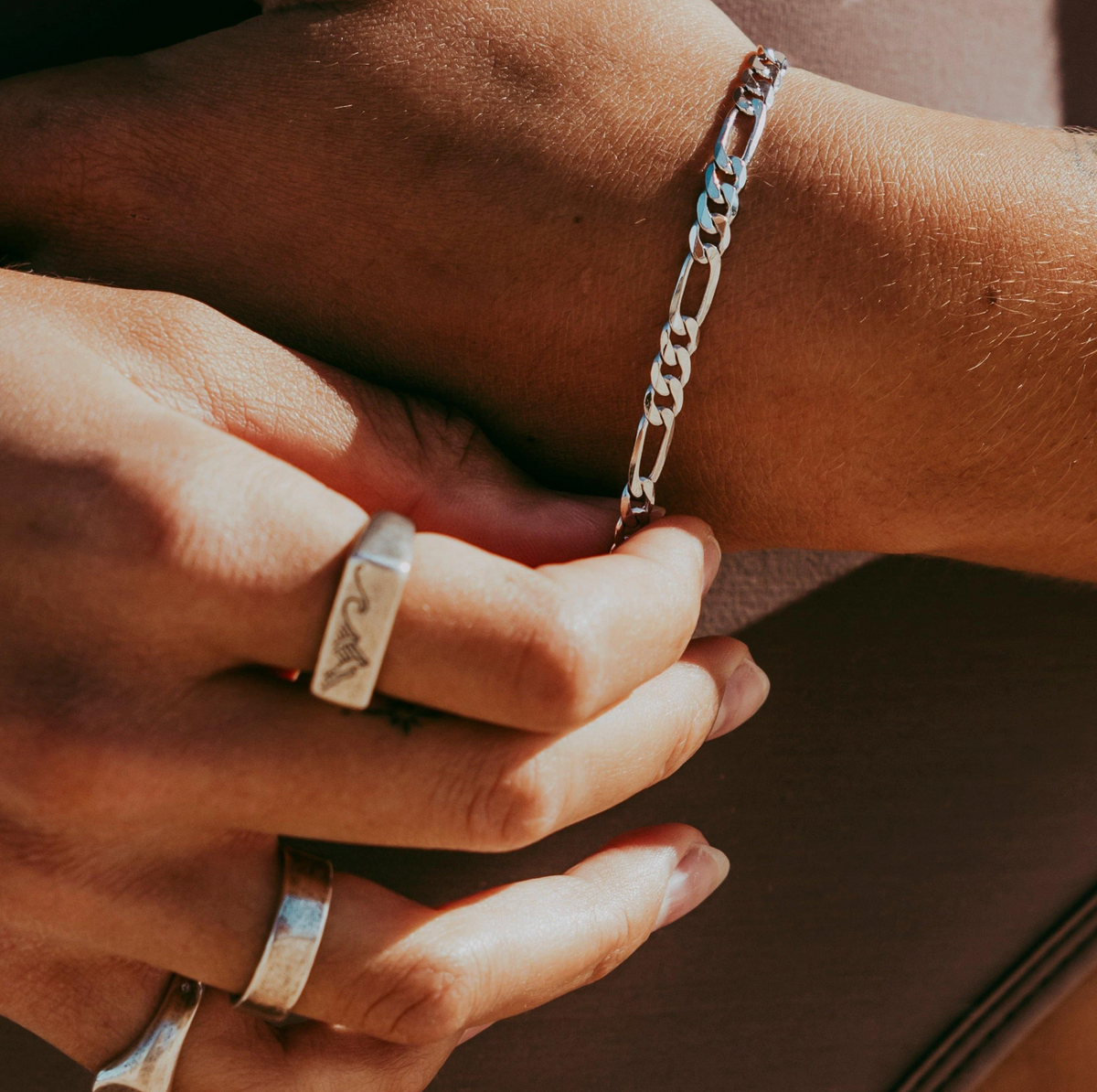A model wearing a polished silver tone  Figaro chain bracelet from Australian jewellery brand Billie Jo