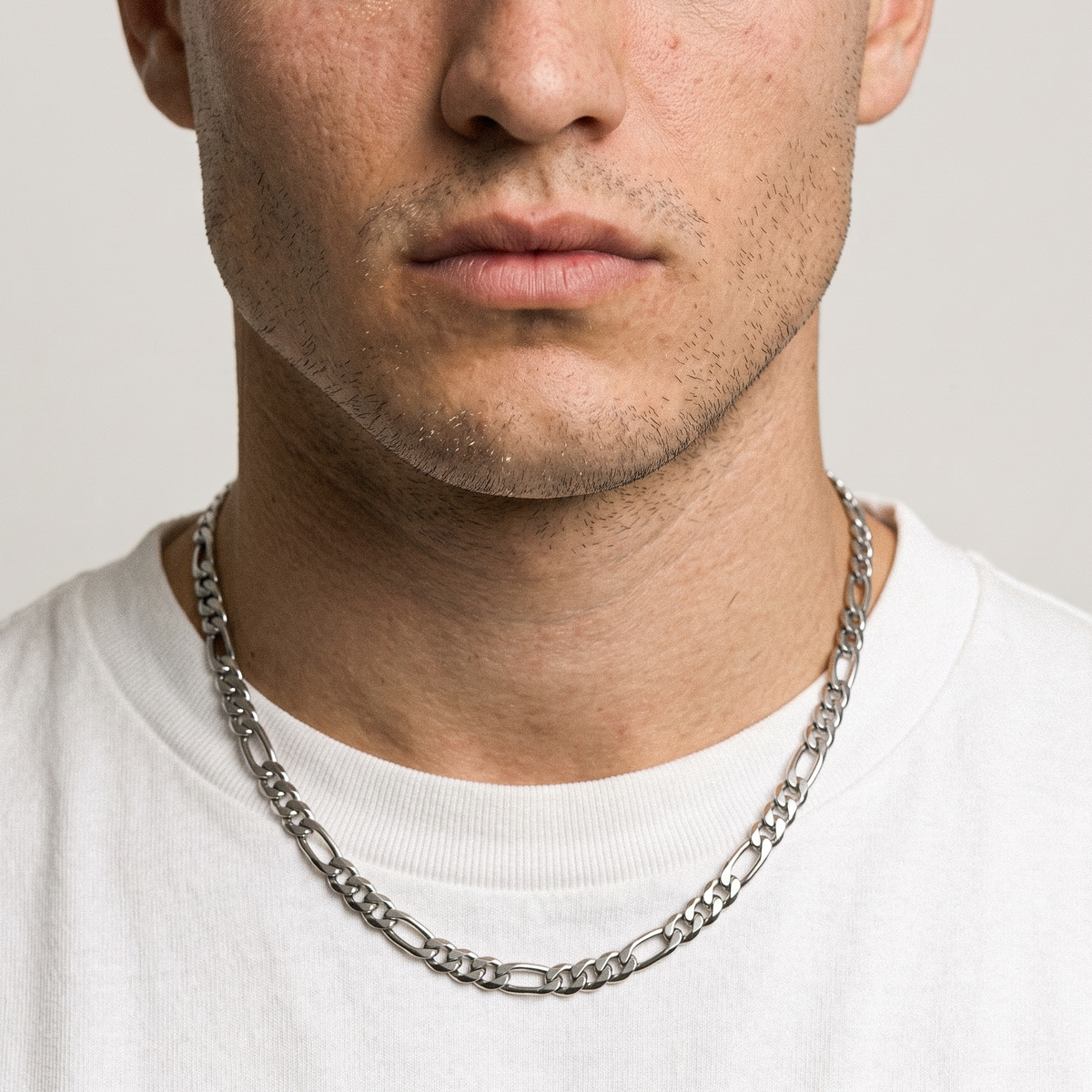 A man wearing a stainless steel men's Figaro chain bracelet from Australian jewellery brand Billie Jo, shot against a neutral background highlighting the thick bold alternating link design