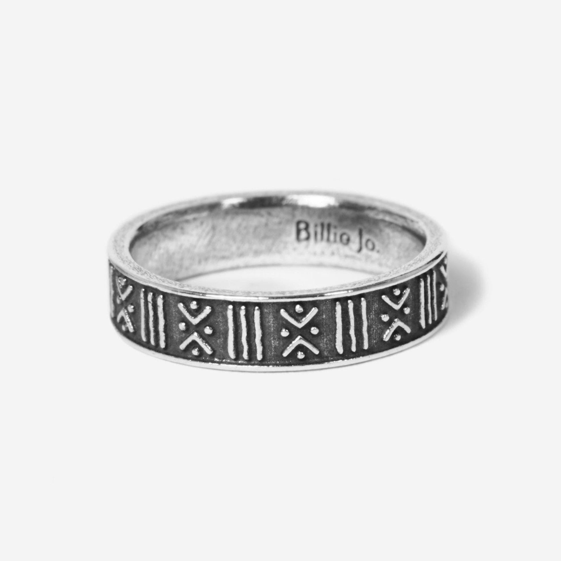 A silver ring featuring an engraved geometric pattern of lines and X shapes, displayed on a plain white background.
