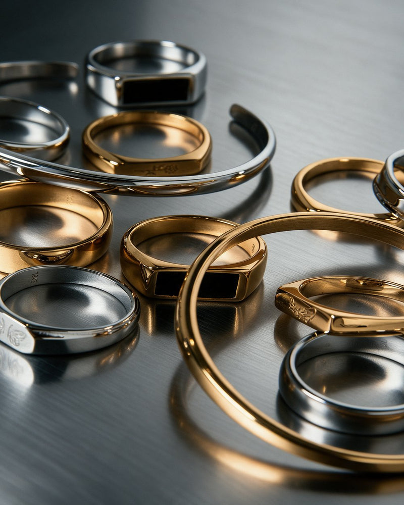 Silver and gold stainless steel rings and cuffs on brushed steel