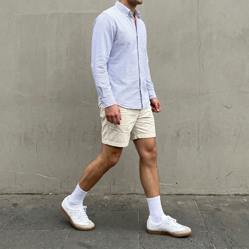 Smart-casual style: striped shirt, shorts and white sneakers