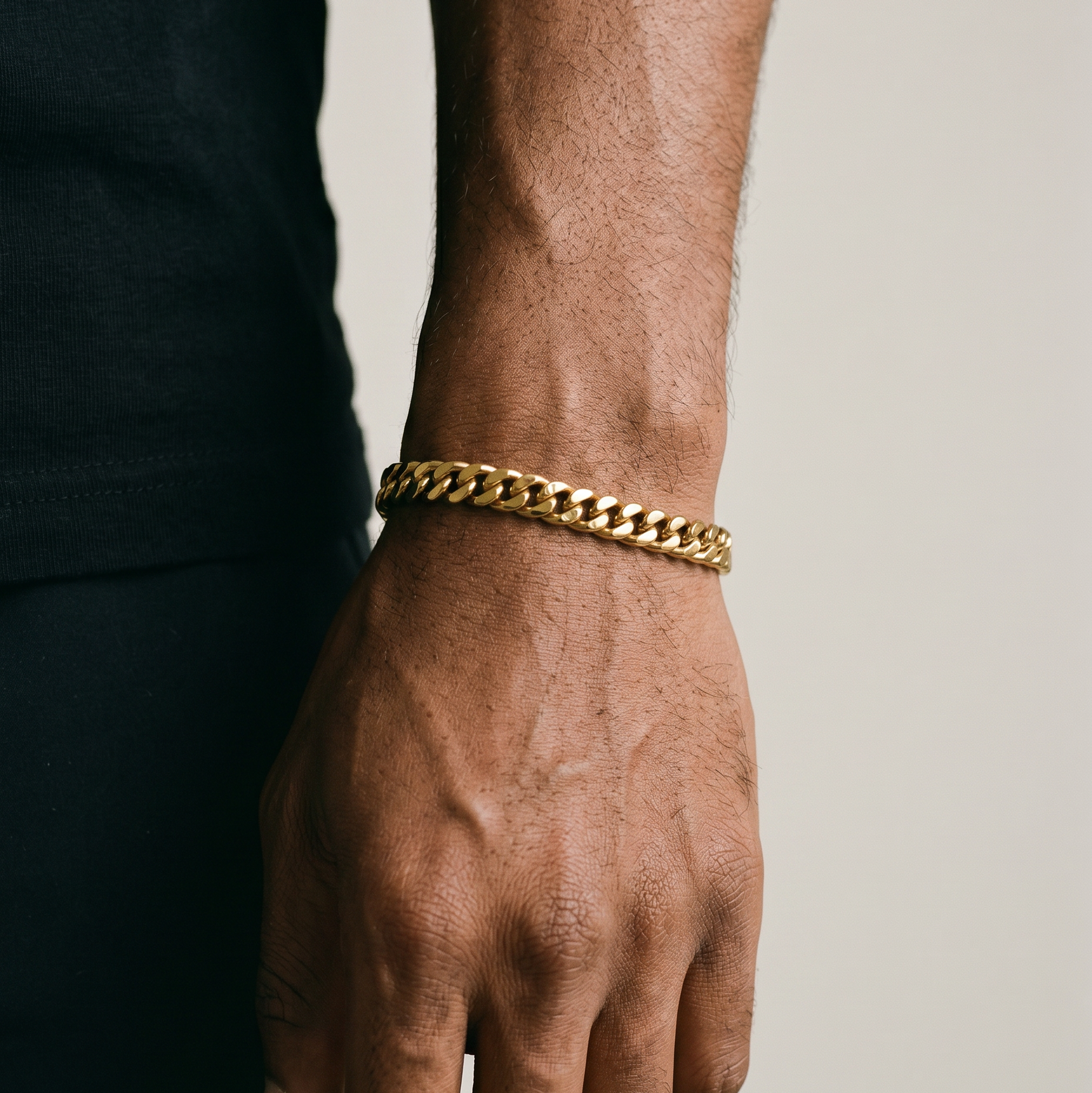 A man wearing a gold stainless steel bracelet layered - from Australian jewellery brand Billie Jo, styled for everyday casual wear.
