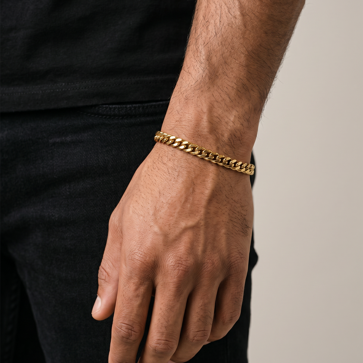 Man wearing a black t-shirt and gold chain bracelet. Waterproof, sweat proof, built to last. 