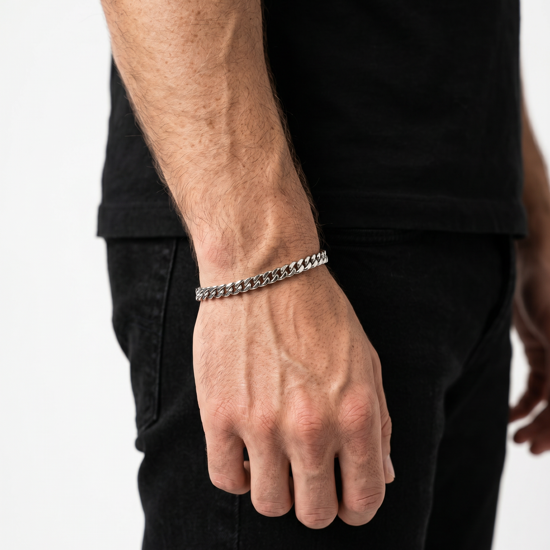 A male model wearing a silver stainless steel slim Figaro chain necklace from Australian jewellery brand Billie Jo, shot against a sleek silver chrome background. 