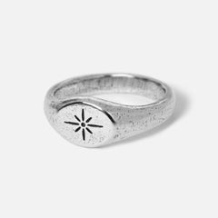 A men's sterling silver signet ring, the Luminous Ring by Billie Jo, with a textured finish and a central starburst engraving. Australian jewellery.