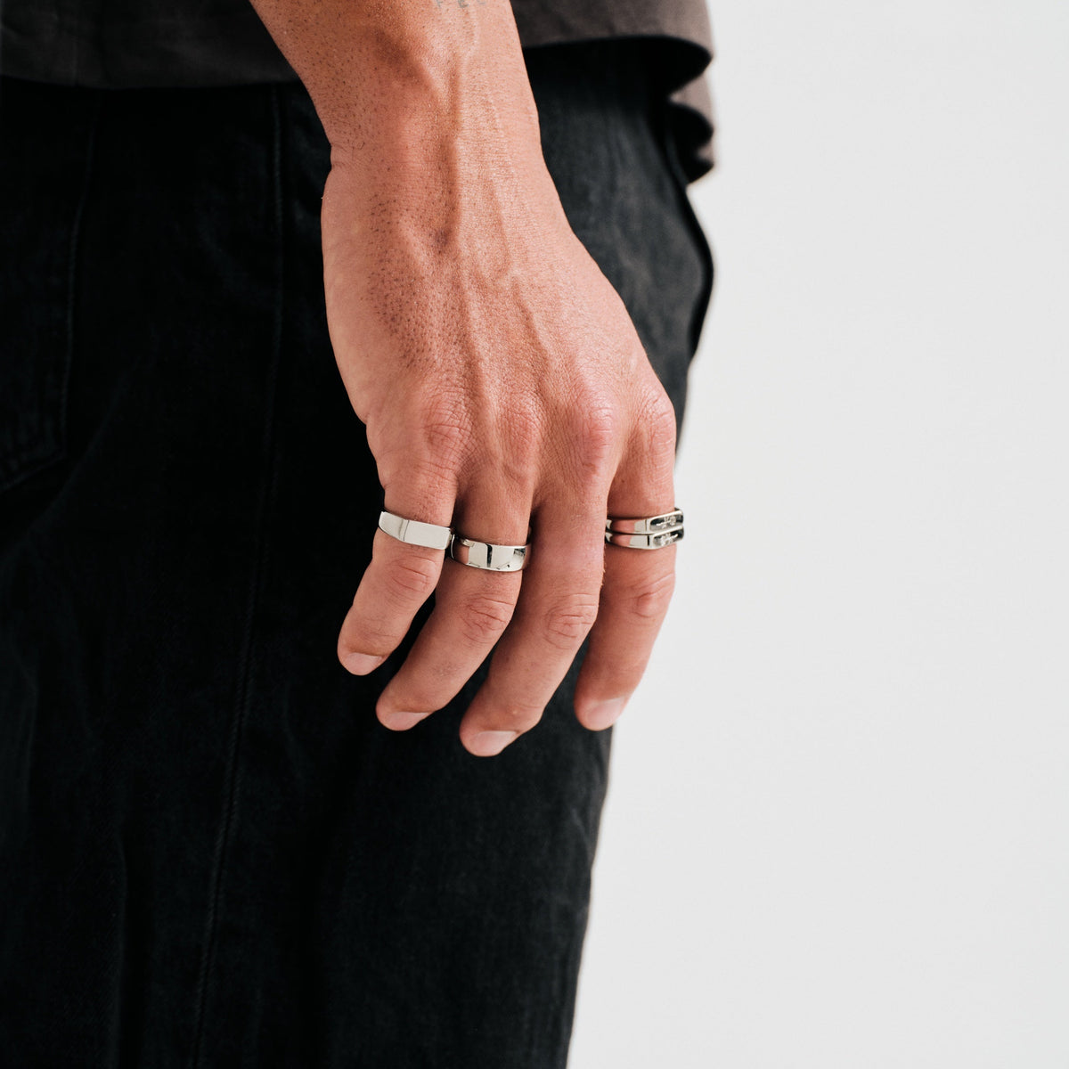 Men's Genesis Ring in 316L stainless steel, silver finish, worn on the little finger, hand hanging at his side