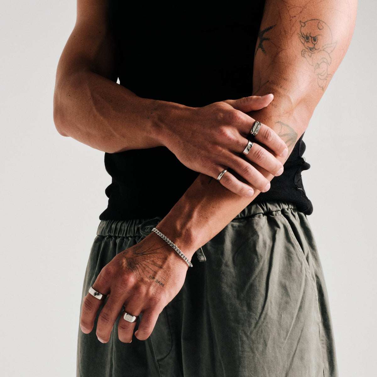 Men's Stacker Rings in 316L stainless steel, silver finish, both worn on the index finger, arms crossed in front