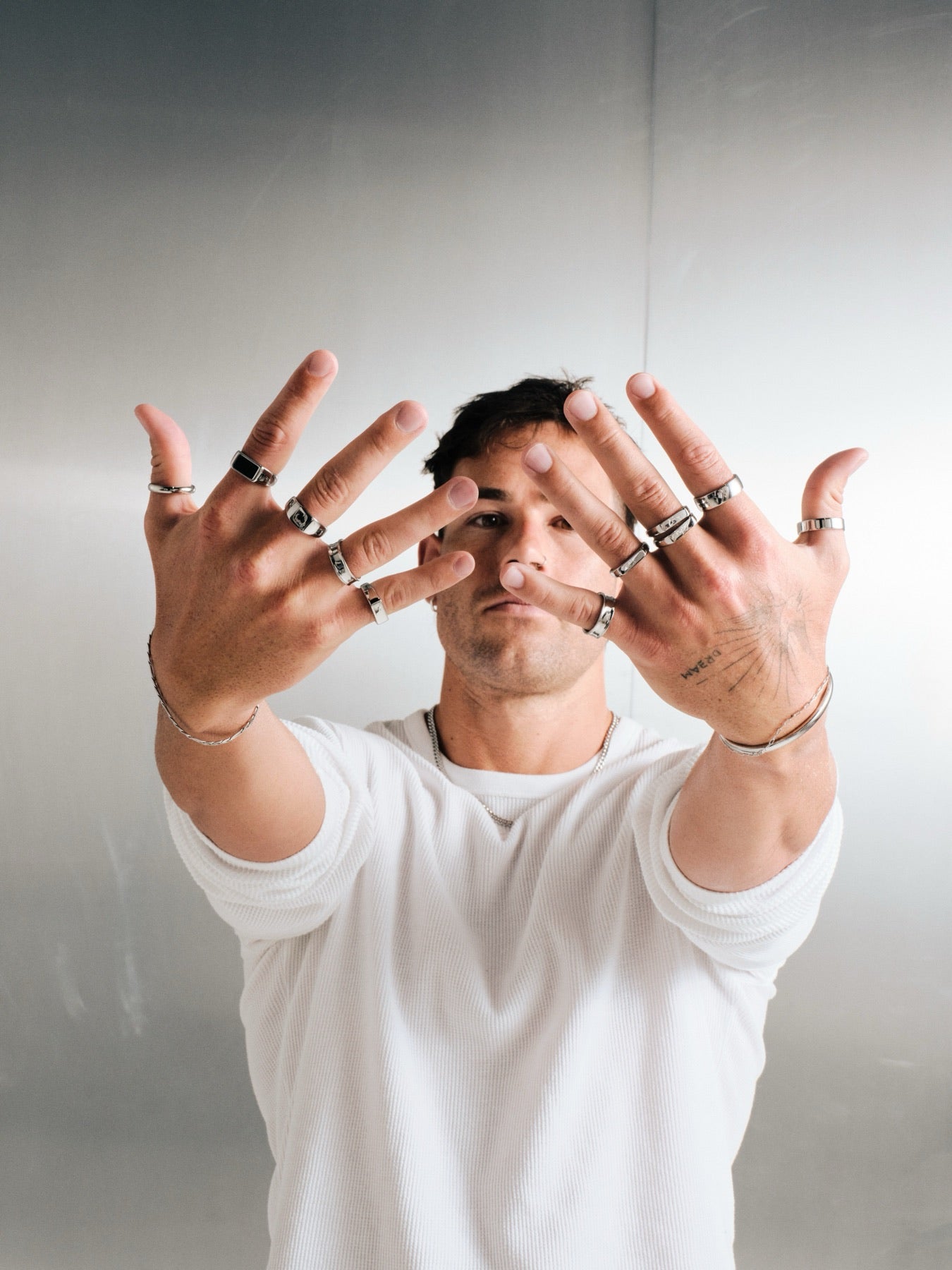 Man holding both hands to the camera wearing Billie Jo stainless steel rings